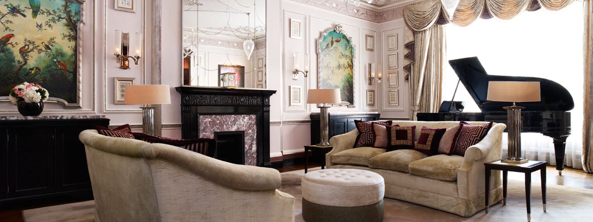 A view of the high-ceilinged drawing room in the Sutherland Suite, with comfortable furnishings and a Steinway grand piano.