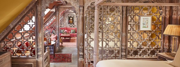 Looking down the centre of The King's Lodge with intricately carved wooden detailing and red interior