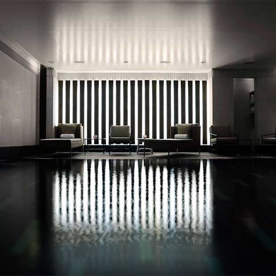 Intimate atmosphere and armchairs for relaxing next to the black granite swimming pool, in Aman Spa.