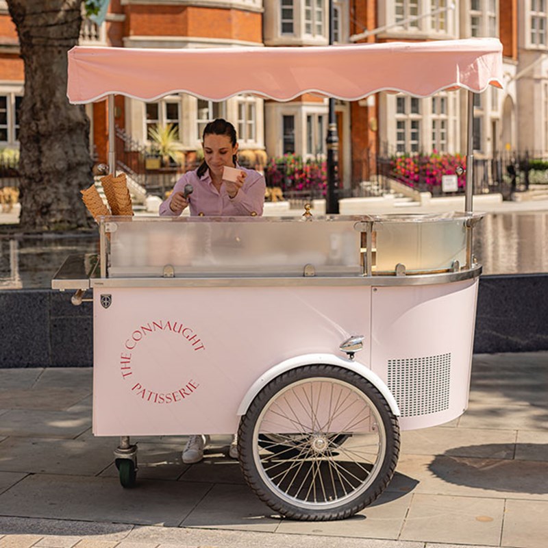 The Connaught Ice Cream Cart outside the fountain with a woman in a pink shirt scooping pink ice cream into a cup