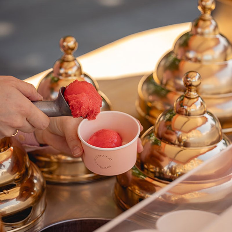 Woman scooping pink ice cream into a cup at The Connaught Ice Cream Cart